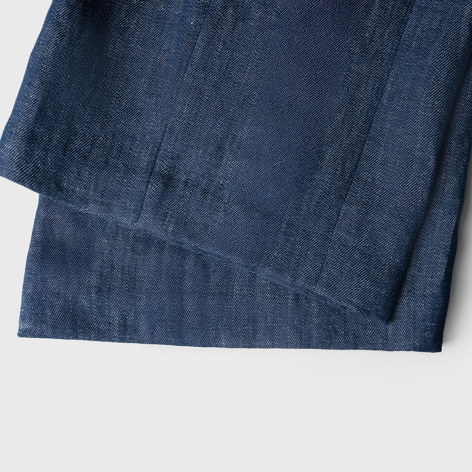 Close-up of a folded blue denim fabric on a white background