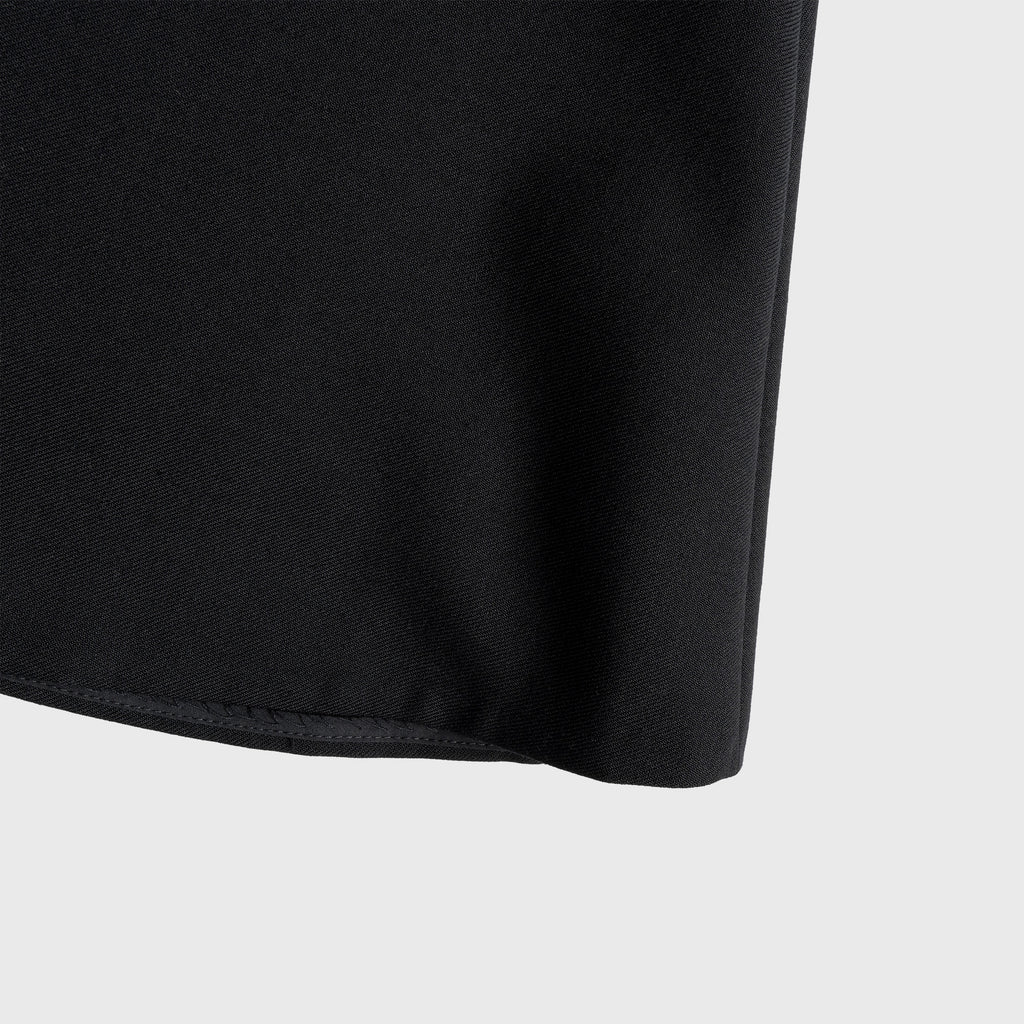 Close-up of a black skirt edge on a light gray background