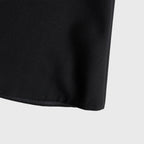 Close-up of a black skirt edge on a light gray background