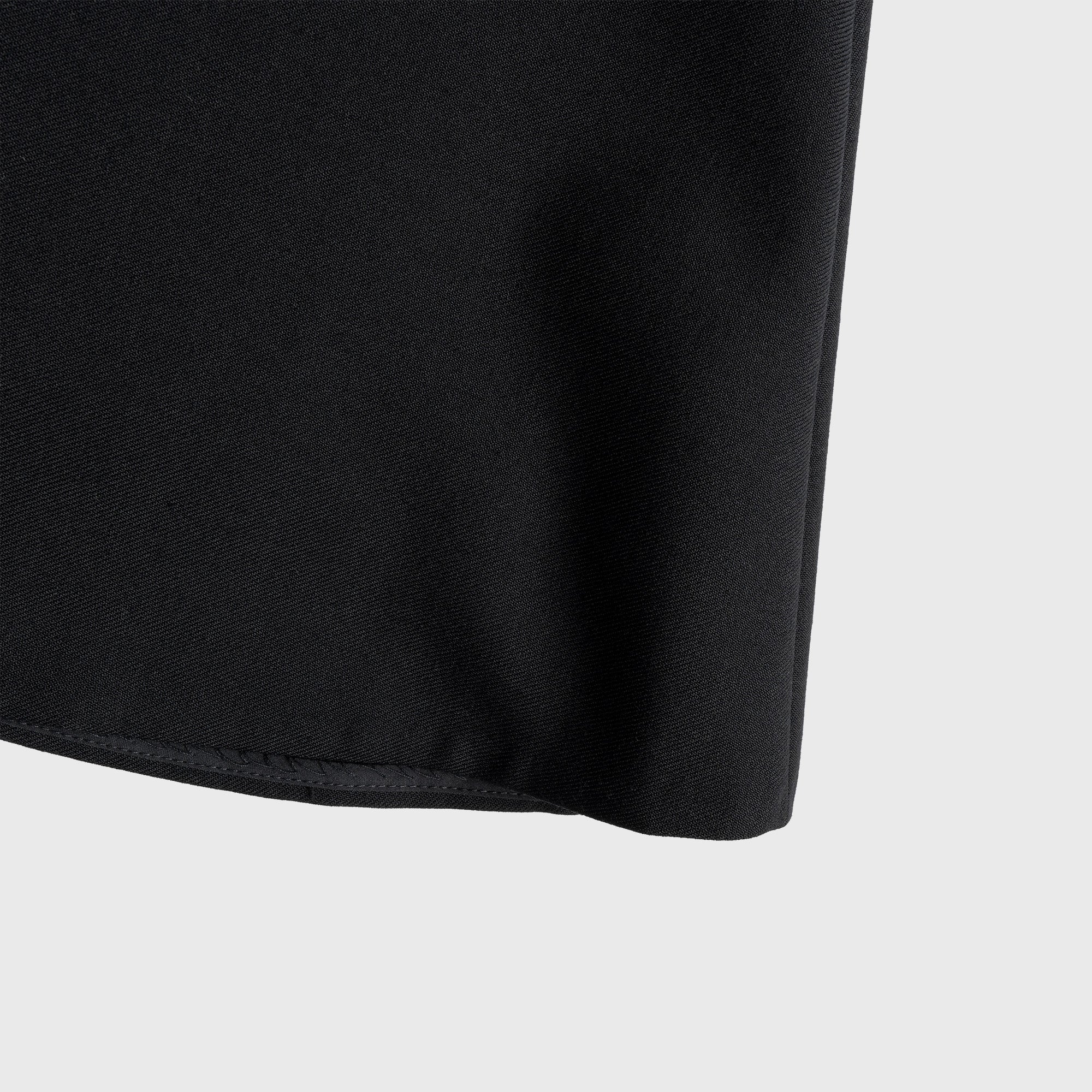Close-up of a black skirt edge on a light gray background