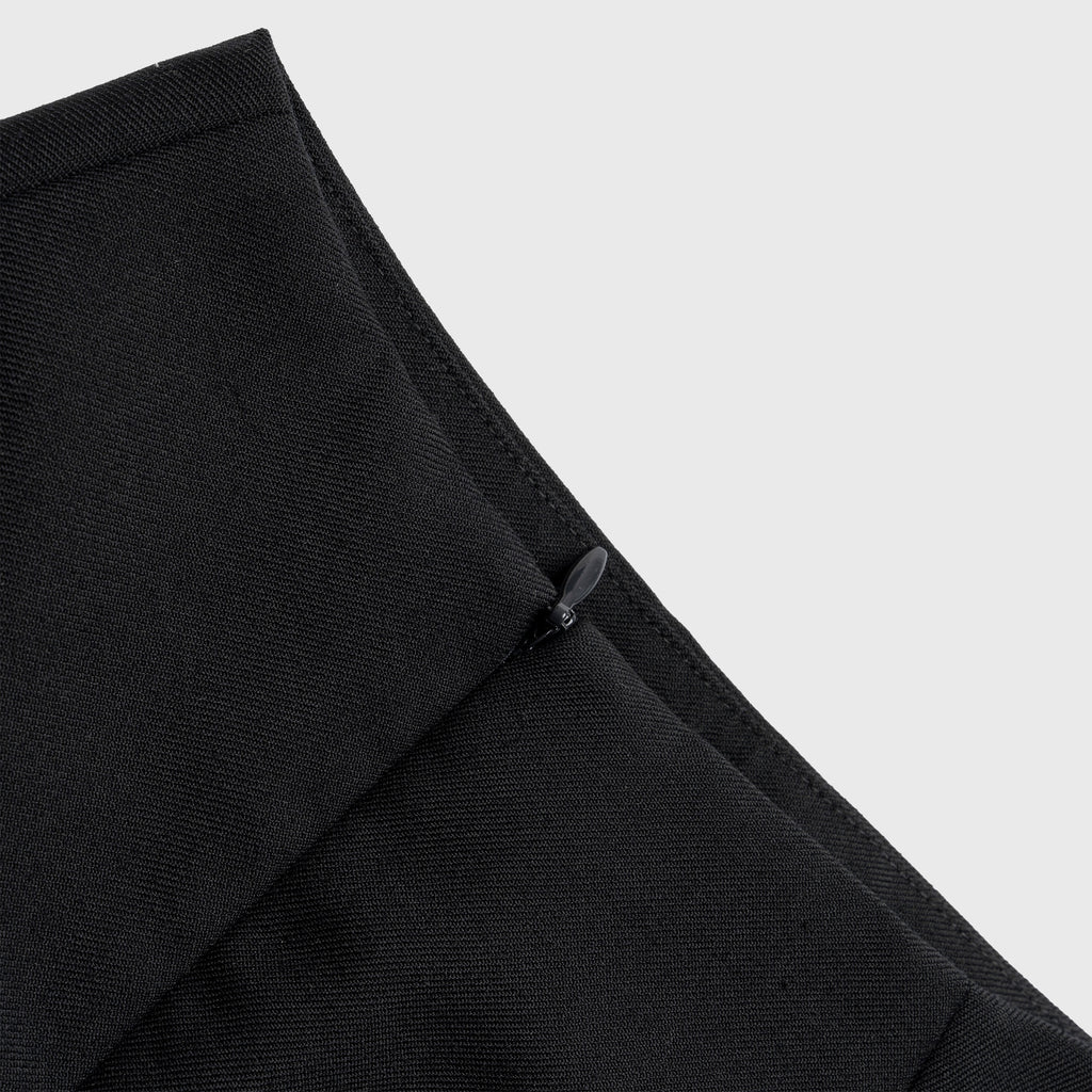 Close-up of a black skirt with a zipper on a light gray background