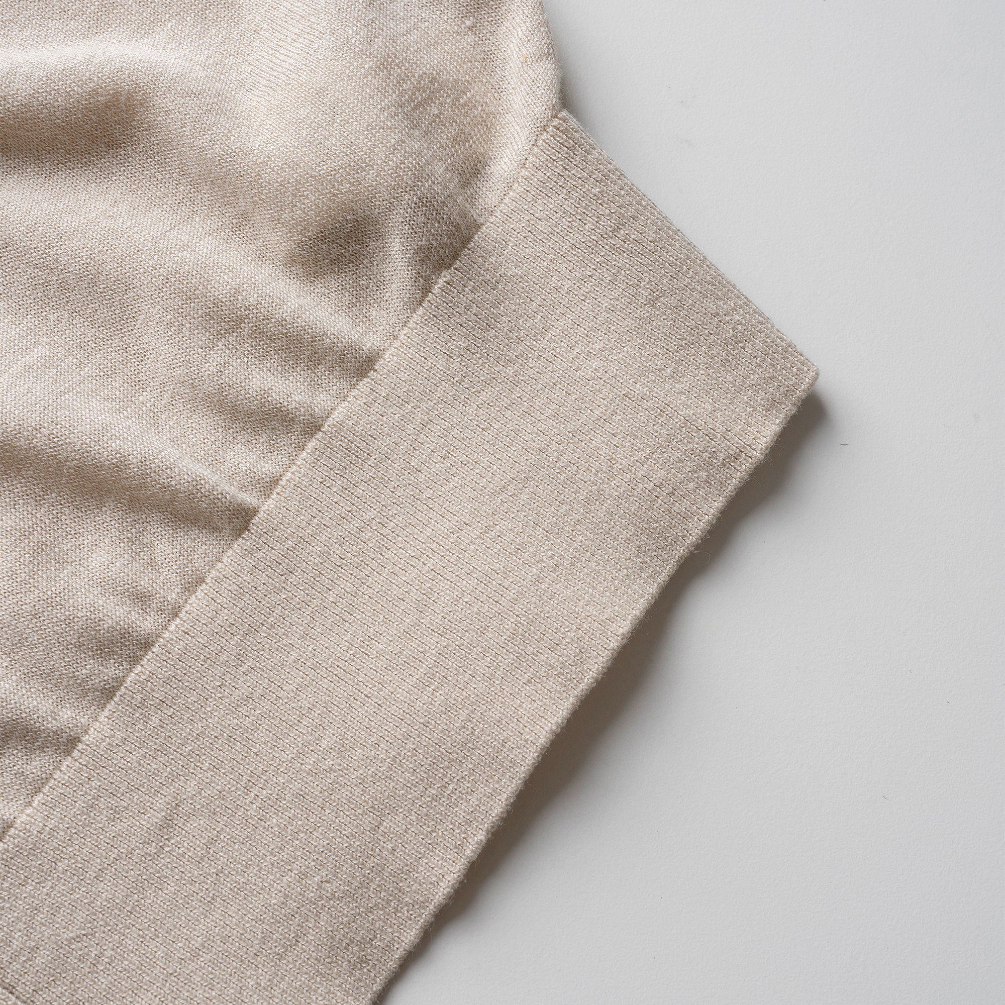 Close-up of beige cardigan with a soft texture on a light gray background