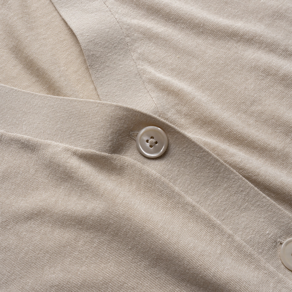 Close-up of beige cardigan with a button