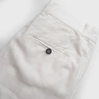 Close-up of white pants with a button on a white background