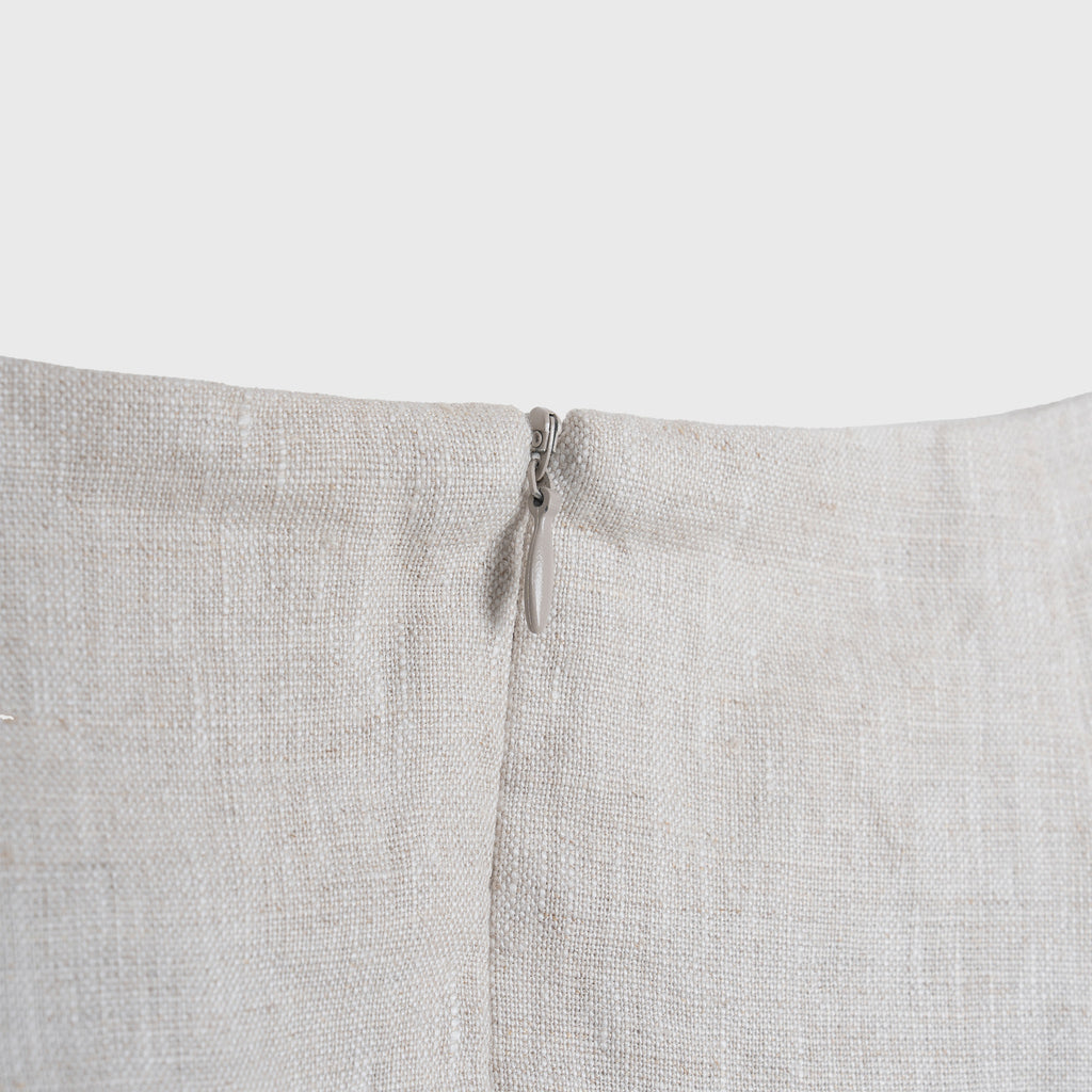 Close-up of a light beige fabric with a zipper on a white background