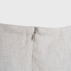 Close-up of a light beige fabric with a zipper on a white background