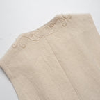 Beige fabric with embroidered detailing on a white background