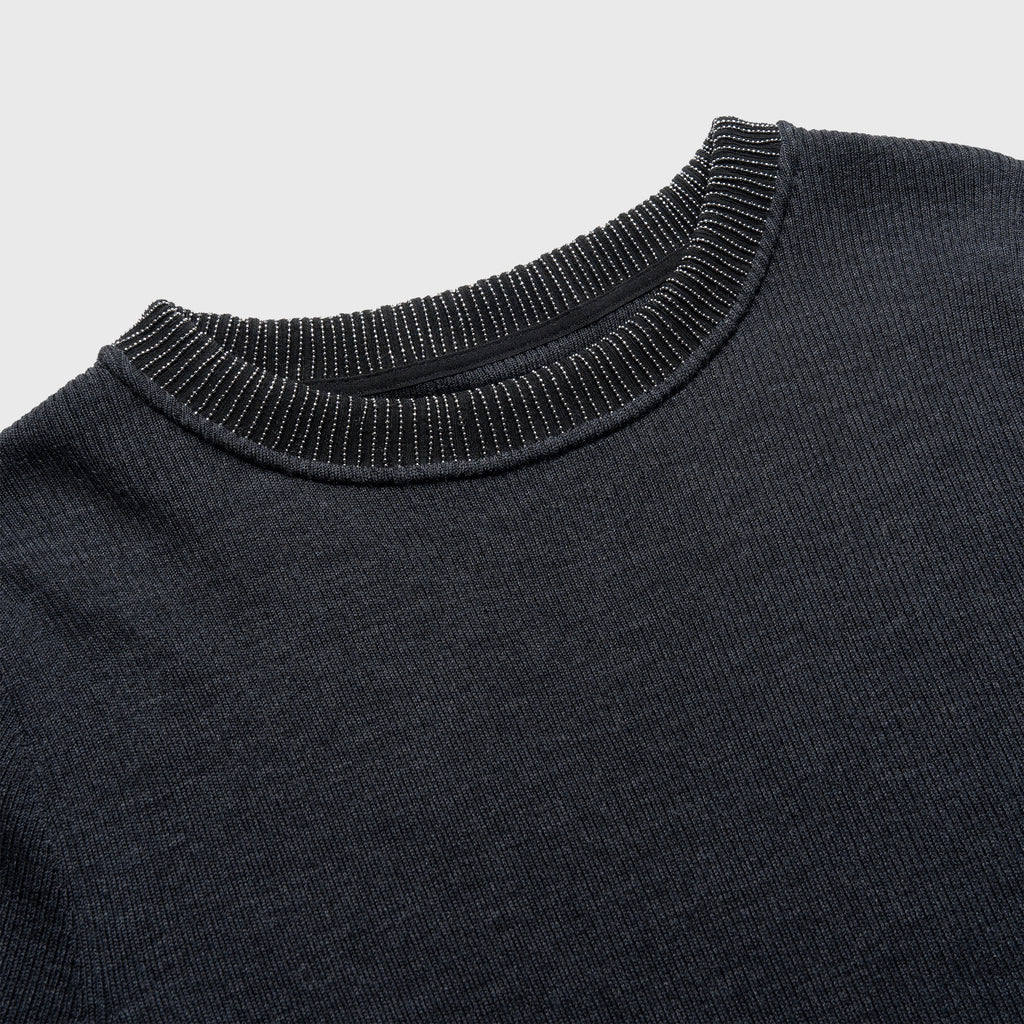 Close-up of a dark gray sweater collar on a light gray background