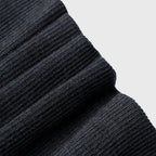 Close-up of black ribbed fabric texture on a light gray background