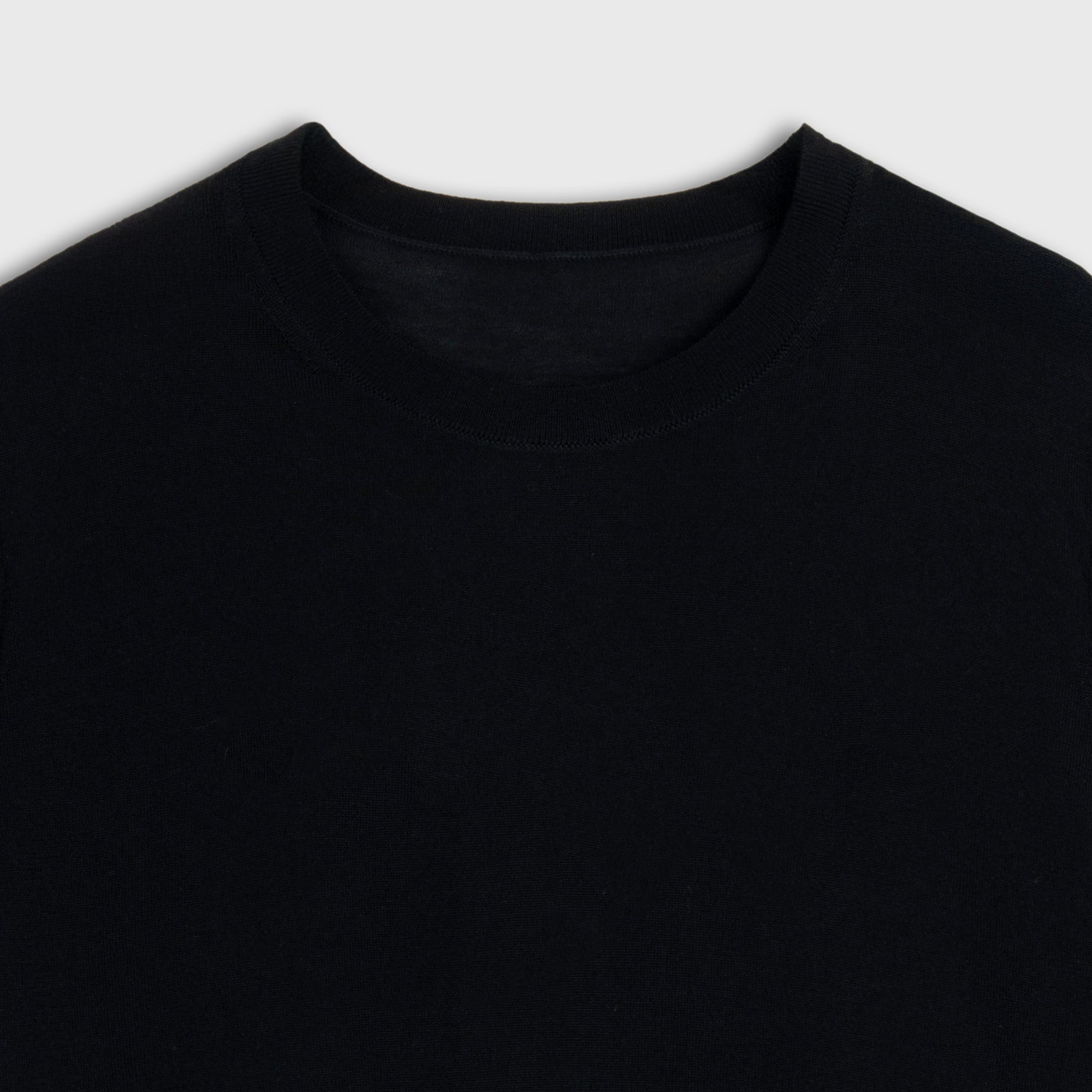 Close-up of a black shirt with a plain background