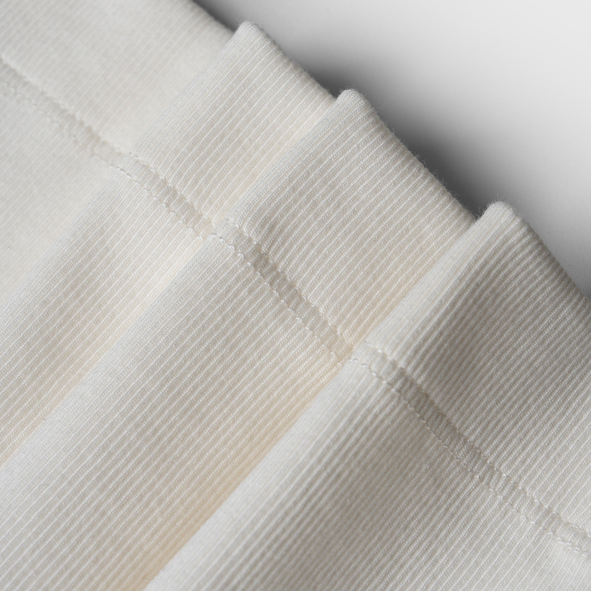 Close-up of folded textured fabric in neutral colors on a light background