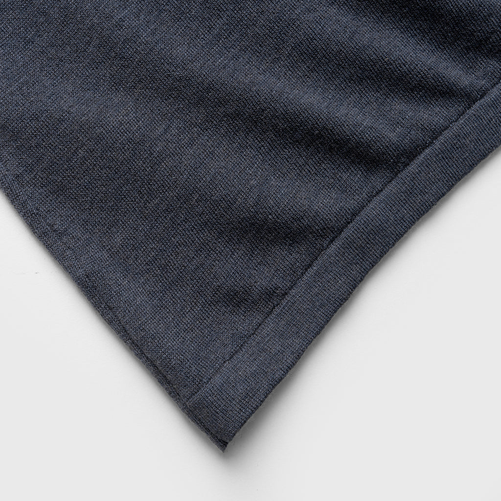 Close-up of a blue denim jacket with white piping on a white background