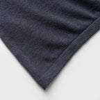 Close-up of a blue denim jacket with white piping on a white background