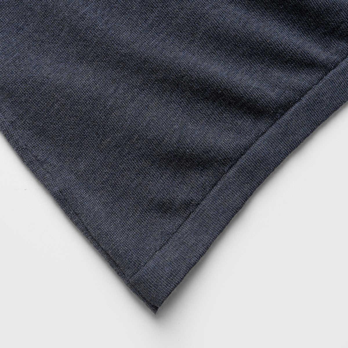 Close-up of a blue denim jacket with white piping on a white background