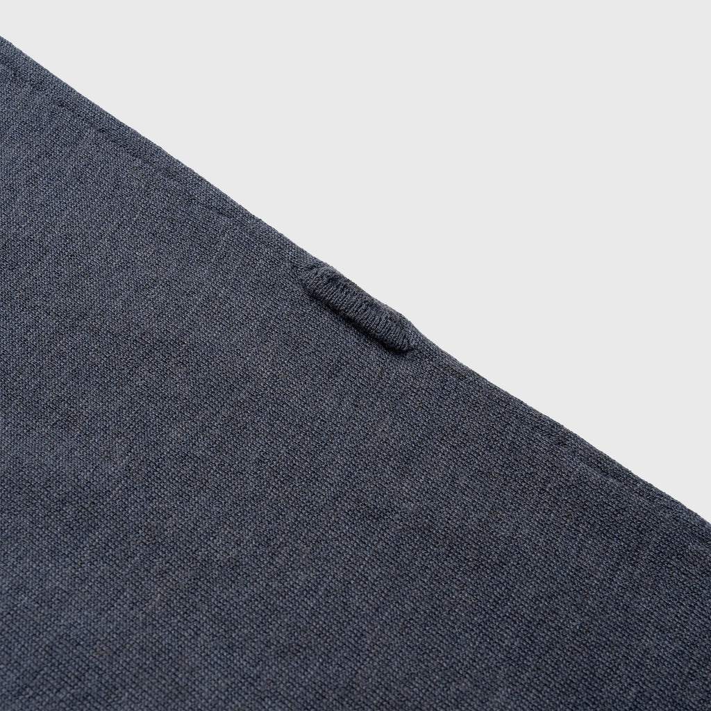 Close-up of a blue denim shirt with buttons on a light gray background