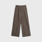 Brown pleated pants on a light gray background