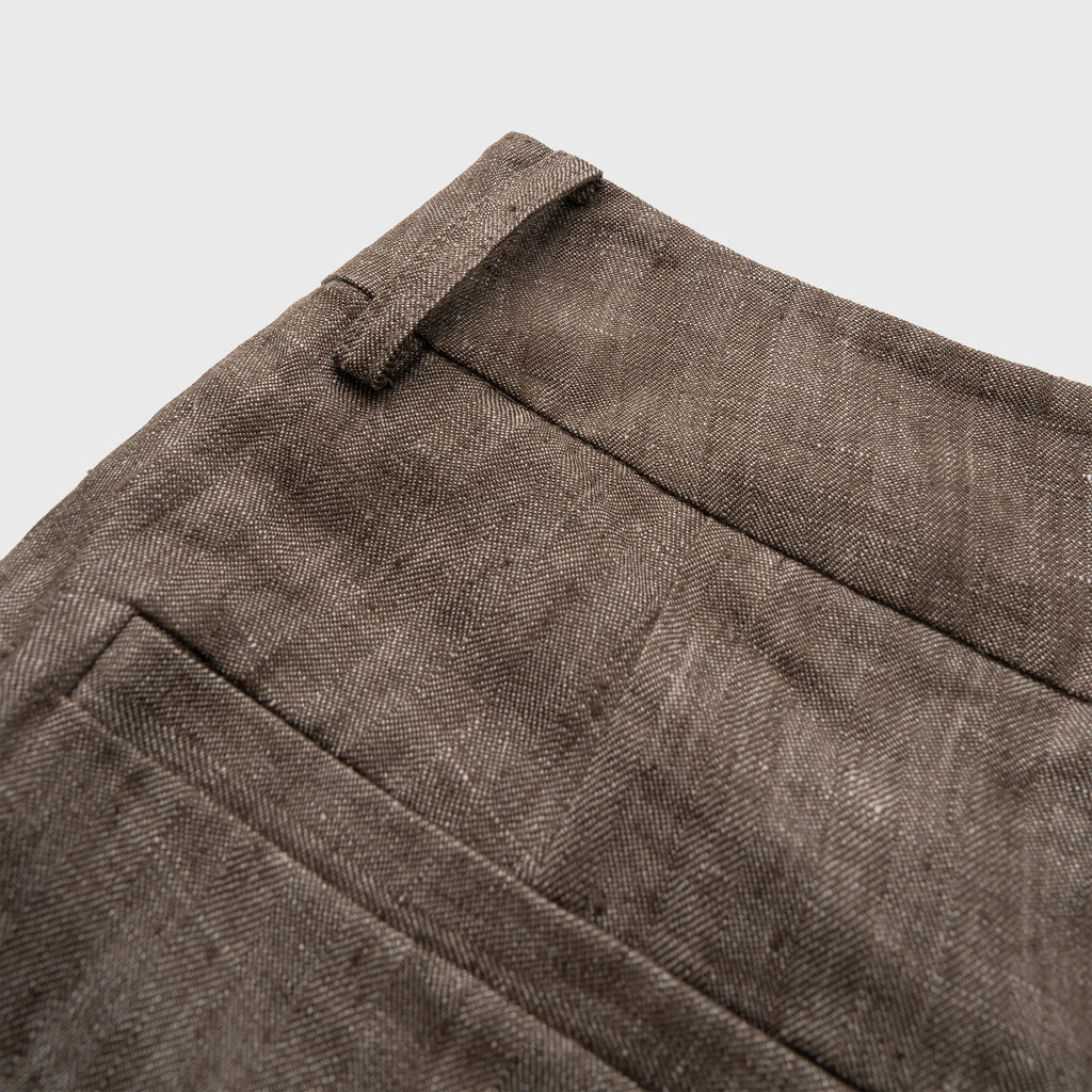 Close-up of brown fabric pant on a light gray background