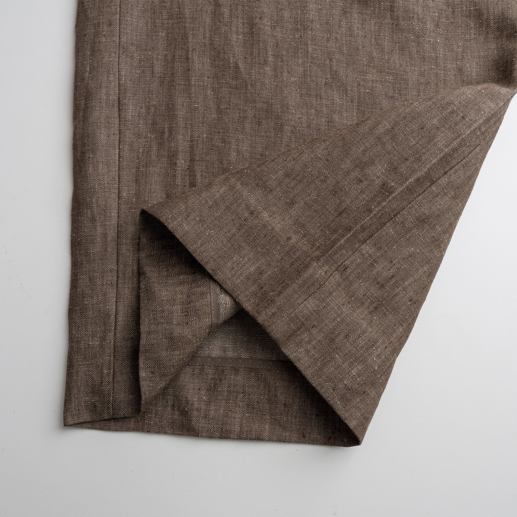 Brown fabric folded Pant on a light gray background