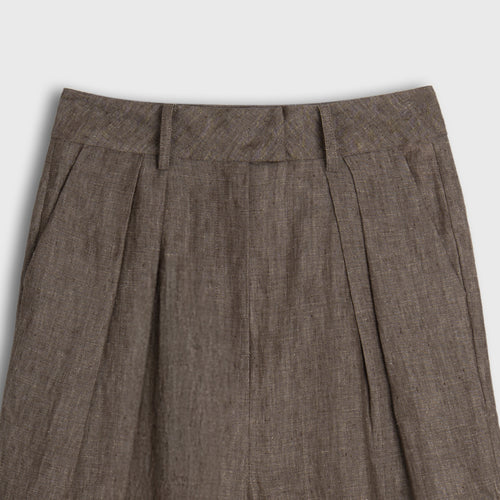 Brown pleated pants on a light gray background