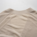 Close-up of a beige cardigan with textured details on a light gray background