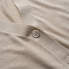 Close-up of beige cardigan with a button