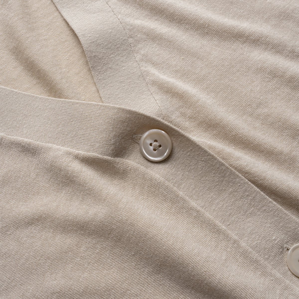 Close-up of beige cardigan with a button