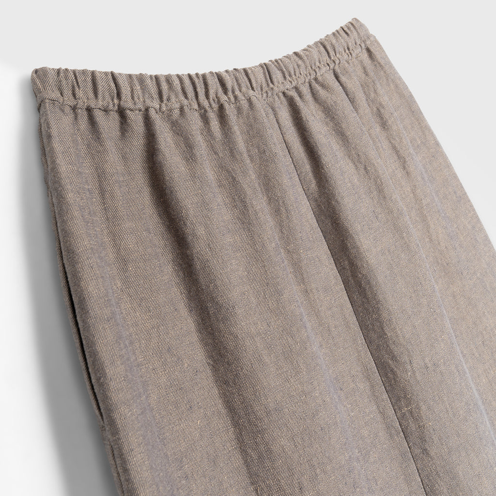 Close-up of beige skirt with an elastic waistband on a light gray background
