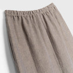 Close-up of beige skirt with an elastic waistband on a light gray background