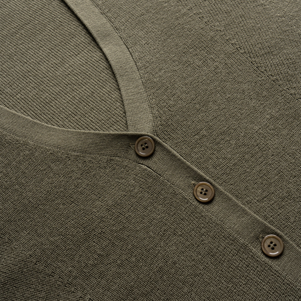 Close-up of a green garment with button details