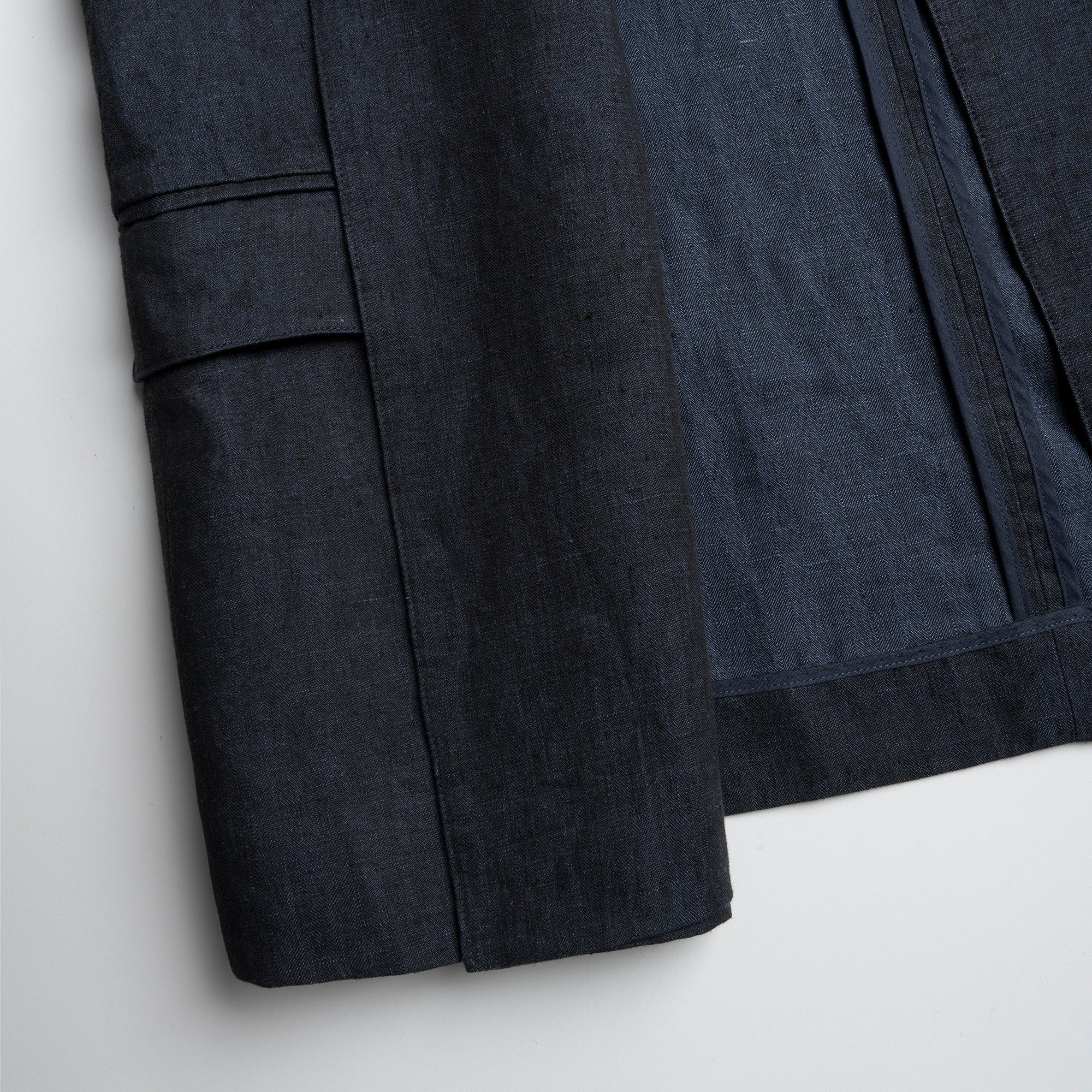 Dark blue fabric with a pocket detail on a light gray background