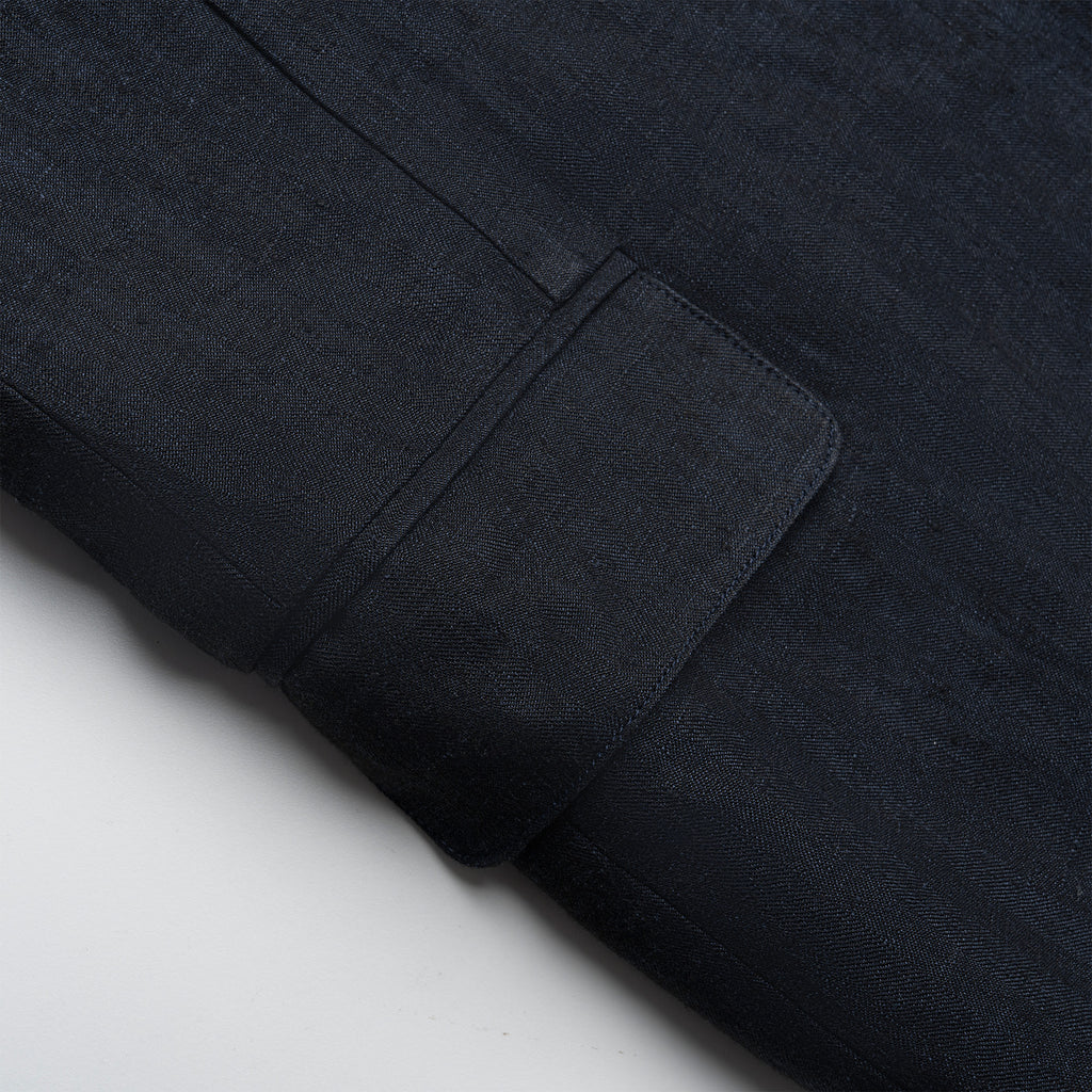 Close-up of a navy fabric with a pocket detail on a light gray background