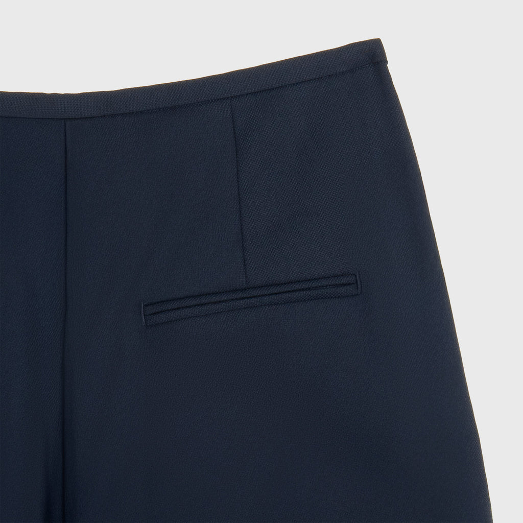Navy blue pants with a pocket on a light gray background