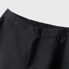 Close-up of black pants with a plain background