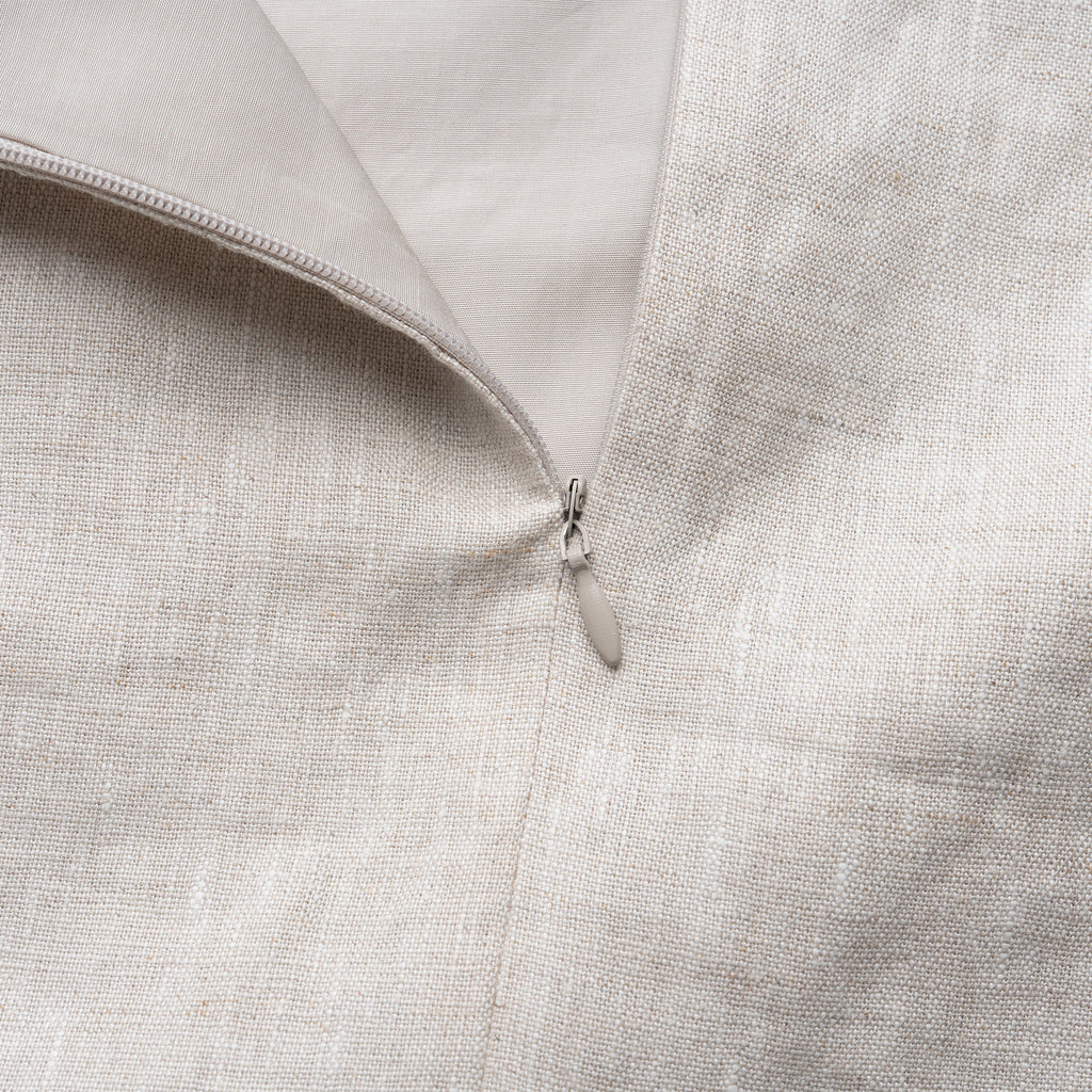 Close-up of a zipper on a light beige fabric