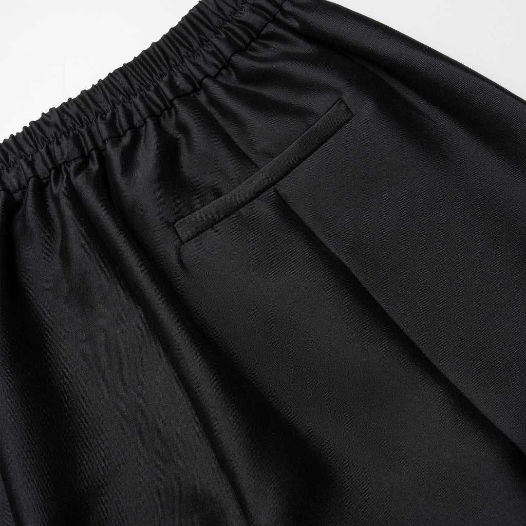 Close-up of black pants with an elastic waistband on a light gray background