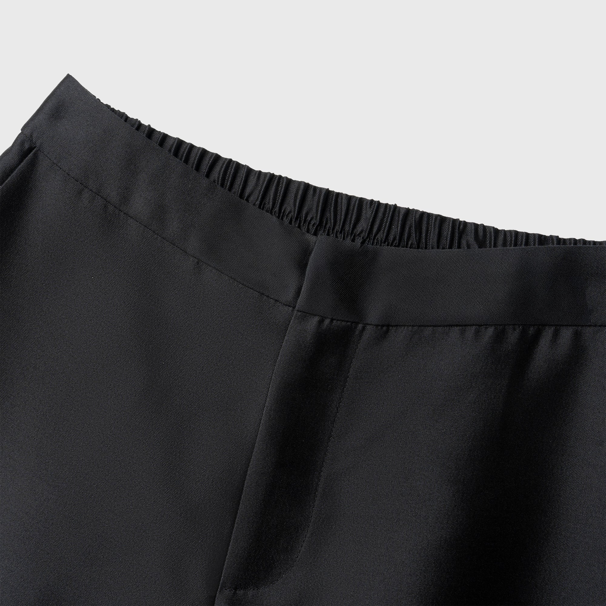 Close-up of black pants with a plain background