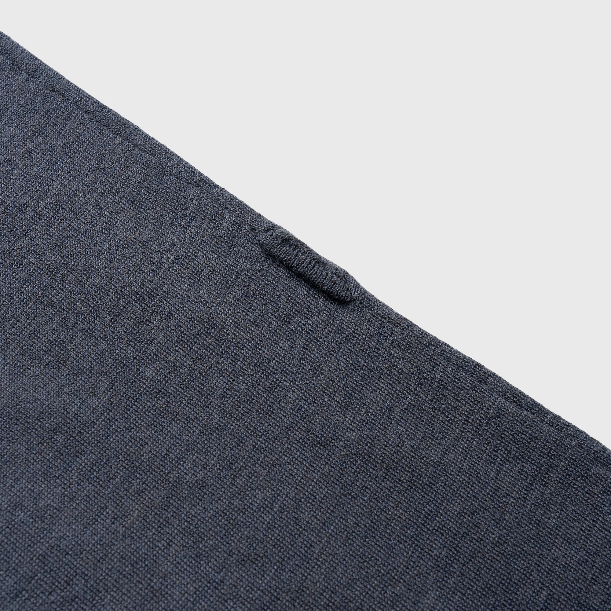 Close-up of a blue denim shirt with buttons on a light gray background