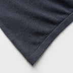 Close-up of a blue denim jacket with white piping on a white background