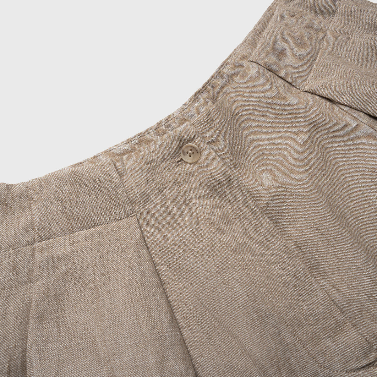 Close-up of beige pants with a button on a light gray background