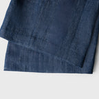 Close-up of a folded blue denim fabric on a white background
