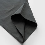 Dark moss green pant fabric with a textured surface on a light gray background