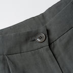 Close-up of a button on a moss greenb fabric with a white background