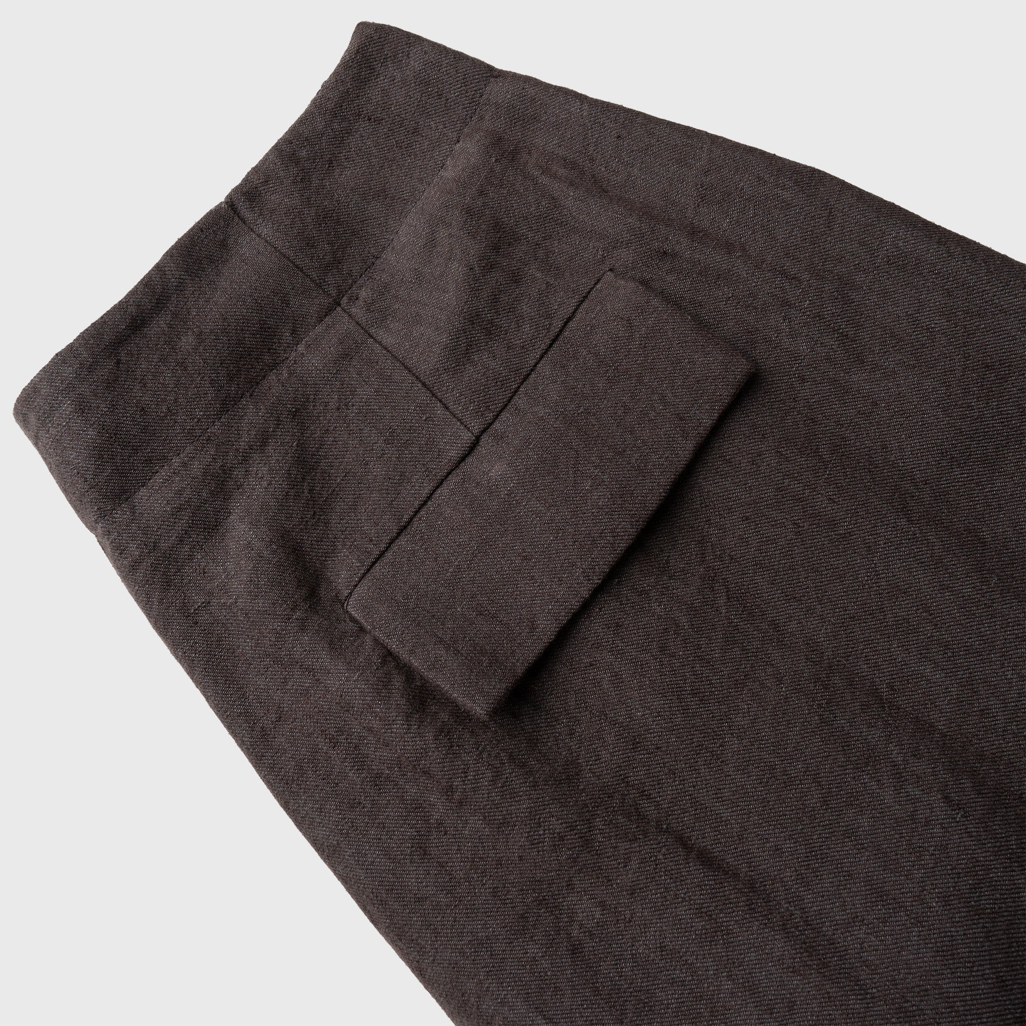 Dark brown pants with a pocket on a light gray background