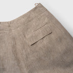 Close-up of beige pants with a pocket on a white background