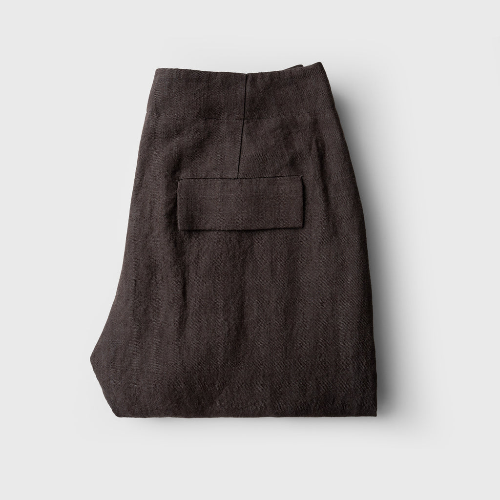 Folded dark brown pants on a light gray background