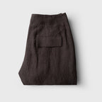 Folded dark brown pants on a light gray background