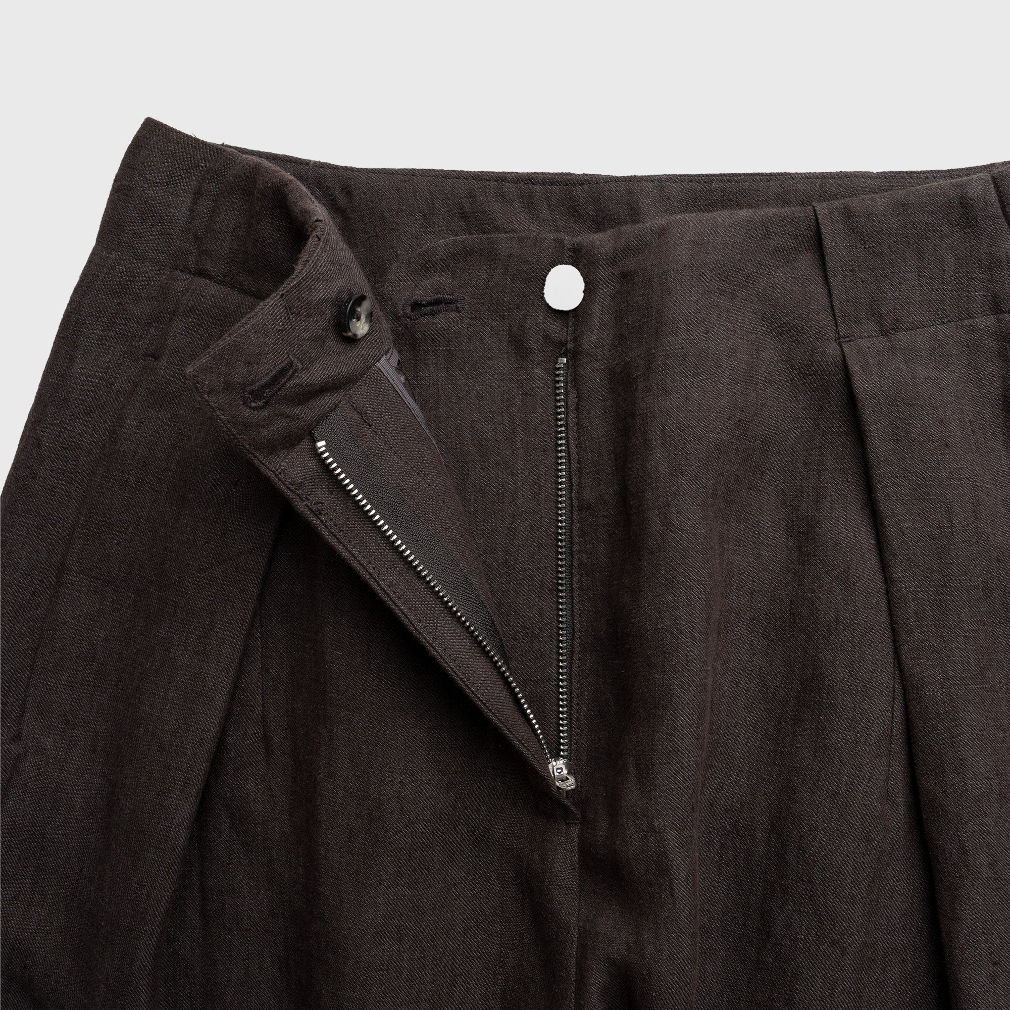 Dark mocha pants with a zipper detail on a light gray background